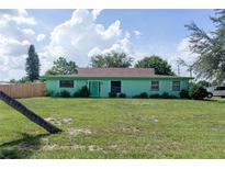 Mint green house with brown roof and green lawn at 15 Winterset Dr, Winter Haven, FL 33884
