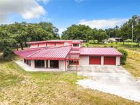 Single-Gathering home with red metal roof and attached garage at 2741 Edwards Rd, Haines City, FL 33844