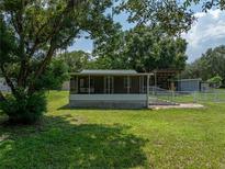 A charming one-story house with a screened porch and well-maintained lawn at 14813 Camp Mack Rd, Lake Wales, FL 33898