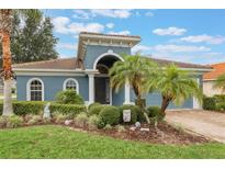 Charming blue two-story home with lush landscaping and a welcoming front entrance at 329 Lake Vista Dr, Auburndale, FL 33823