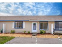 Tan house with blue trim and landscaping at 61 Winter Ridge Rd # 54, Winter Haven, FL 33881