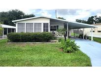 Mobile home with carport and landscaped yard at 191 Sweet Cir, Winter Haven, FL 33884
