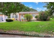 Charming ranch home with pink exterior, lush lawn, and mature landscaping at 512 N 4Th St, Haines City, FL 33844