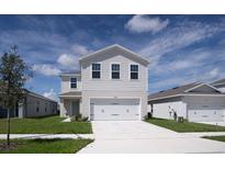 Two-story house with a two-car garage and well-maintained lawn at 5031 Starboard St, Haines City, FL 33844