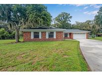 Brick ranch home with a two-car garage and spacious lawn at 3050 Cross Fox Dr, Mulberry, FL 33860