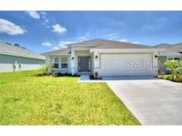 One-story home with a two car garage and front yard at 1560 Leamington Lane, Winter Haven, FL 33884