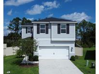 Two-story house with grey siding, white garage door, and landscaping at 1011 Overlook Ct, Davenport, FL 33837