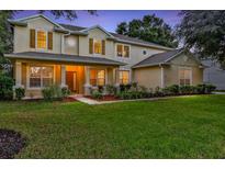 Two-story house with landscaped yard, lit at dusk at 2433 Home Again Rd, Apopka, FL 32712