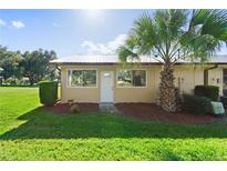 Exterior view of a condo with a palm tree and manicured lawn at 1086 Pelham Ct, Winter Haven, FL 33884