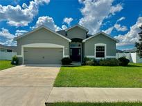 One-story house with gray siding and two-car garage at 991 First Dr, Eagle Lake, FL 33839