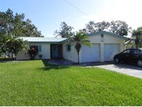 Single-story house with a two-car garage and a lawn at 2201 W Pilaklakaha Ave, Auburndale, FL 33823