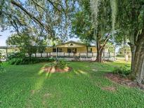 Ranch style home with large front porch and mature trees at 126 Bermuda Ct, Winter Haven, FL 33880