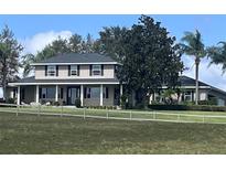 Two-story house with large front porch and landscaping at 905 N Crooked Lake Dr, Babson Park, FL 33827