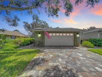 Attached garage with paver driveway and American flag at 579 Saint Andrews Rd, Winter Haven, FL 33884