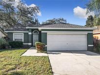 Green house with white garage door and well-maintained lawn at 960 Old Cutler Rd, Lake Wales, FL 33898