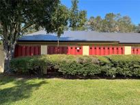 Condo exterior with red fence and landscaping at 1039 Medinah Dr, Winter Haven, FL 33884