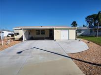 House exterior featuring a single-story home with carport and well-maintained landscaping at 312 Douglas Park Ave, Davenport, FL 33897