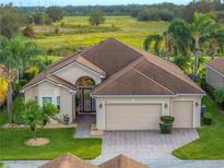 One-story home with a two-car garage, paver driveway, and lush landscaping at 4193 Stone Creek Loop, Lake Wales, FL 33859