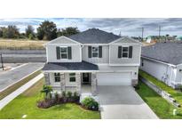 Two-story house with gray siding, stone accents, and a two-car garage at 9660 Westside Hills Dr, Davenport, FL 33896