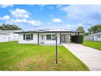 Updated single-story home with solar panels, carport, and well-manicured lawn at 105 Elliott Ln, Winter Haven, FL 33884