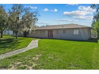 Ranch style home with carport, well-manicured lawn, and walkway at 501 Arneson Ave, Auburndale, FL 33823