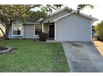 Cute one-story house with gray siding, a blue door, and a well-manicured lawn at 1082 Sunshine Sw Way, Winter Haven, FL 33880