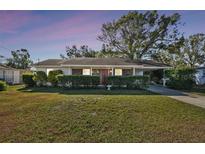 Charming single story home with a well-manicured lawn and mature trees at 122 Alvina Ave, Lake Wales, FL 33853