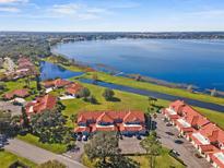 Stunning aerial view of a waterfront community with lush landscaping and serene lake at 802 Magnolia Pl, Winter Haven, FL 33884