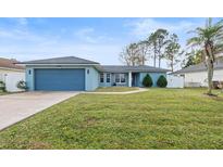 Charming single-story home with a blue exterior and well-maintained lawn at 910 Nancy Ct, Kissimmee, FL 34759