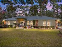 House exterior at dusk with lights on, showcasing curb appeal at 9365 Lemon Dr, Lake Wales, FL 33898