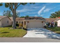 Tan single-story home with attached garage and mature landscaping at 3909 Cypress E Lndg, Winter Haven, FL 33884