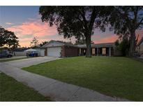 Brick house with attached garage and well-manicured lawn at 1609 Seneca Ave, Lakeland, FL 33801