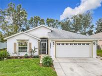 White house with a two-car garage and well-maintained lawn at 235 Lake Suzanne Dr, Lake Wales, FL 33859