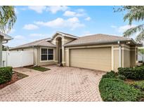 Beige one-story house with a two-car garage and paved driveway at 3421 Grenville Dr, Winter Haven, FL 33884