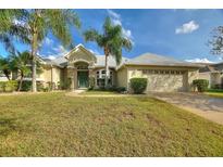 Single-story house with a two-car garage and palm trees in the front yard at 357 Magneta Loop, Auburndale, FL 33823