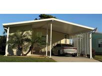 Mobile home with carport and landscaped yard at 418 Village Sw Cir, Winter Haven, FL 33880