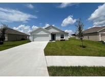 Newly built home with a two-car garage and grassy yard at 1057 Bergamot Dr, Bartow, FL 33830