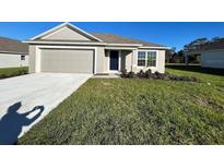 Newly constructed one-story home with attached garage and well-manicured lawn at 2169 Emma Ln, Lake Wales, FL 33859