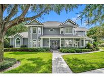 Two-story home with gray siding, stone walkway, and lush landscaping at 122 Stone Hill Dr, Maitland, FL 32751