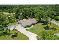 Aerial view of a single-story home with a large yard and paved driveway at 213 Riverbend Rd, Ormond Beach, FL 32174