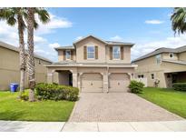 Two-story house with two-car garage and palm trees at 2720 Monticello Way, Kissimmee, FL 34741