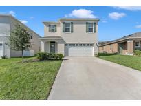 Two-story home with attached garage and well-maintained lawn at 2557 Shamrock St, Tavares, FL 32778