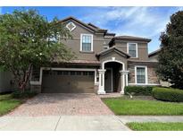 Two-story house with a brown facade and brick driveway at 1402 Wexford Way, Davenport, FL 33896