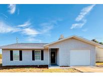 Newly constructed home with white brick exterior, gray roof and attached garage at 9115 Se 88Th St, Ocala, FL 34472