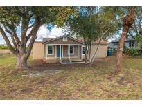 Newly renovated house with teal front door, and a porch at 13 E 8Th St, Frostproof, FL 33843