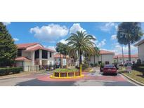 Exterior view of townhome community with gated entrance and lush landscaping at 6274 Whispering Way # 130, Orlando, FL 32807