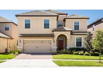 Two-story house with a two-car garage and manicured lawn at 1502 Moon Valley Dr, Davenport, FL 33896