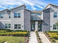 Modern two-story townhome with gray siding and stone accents at 580 Pebble Beach Dr, Davenport, FL 33896