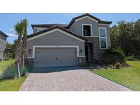 Two-story home with gray siding and brick accents at 3937 Reed Grass Pl, Kissimmee, FL 34746