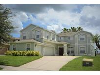 Two-story house with a three car garage and manicured lawn at 13900 Fox Glove St, Winter Garden, FL 34787